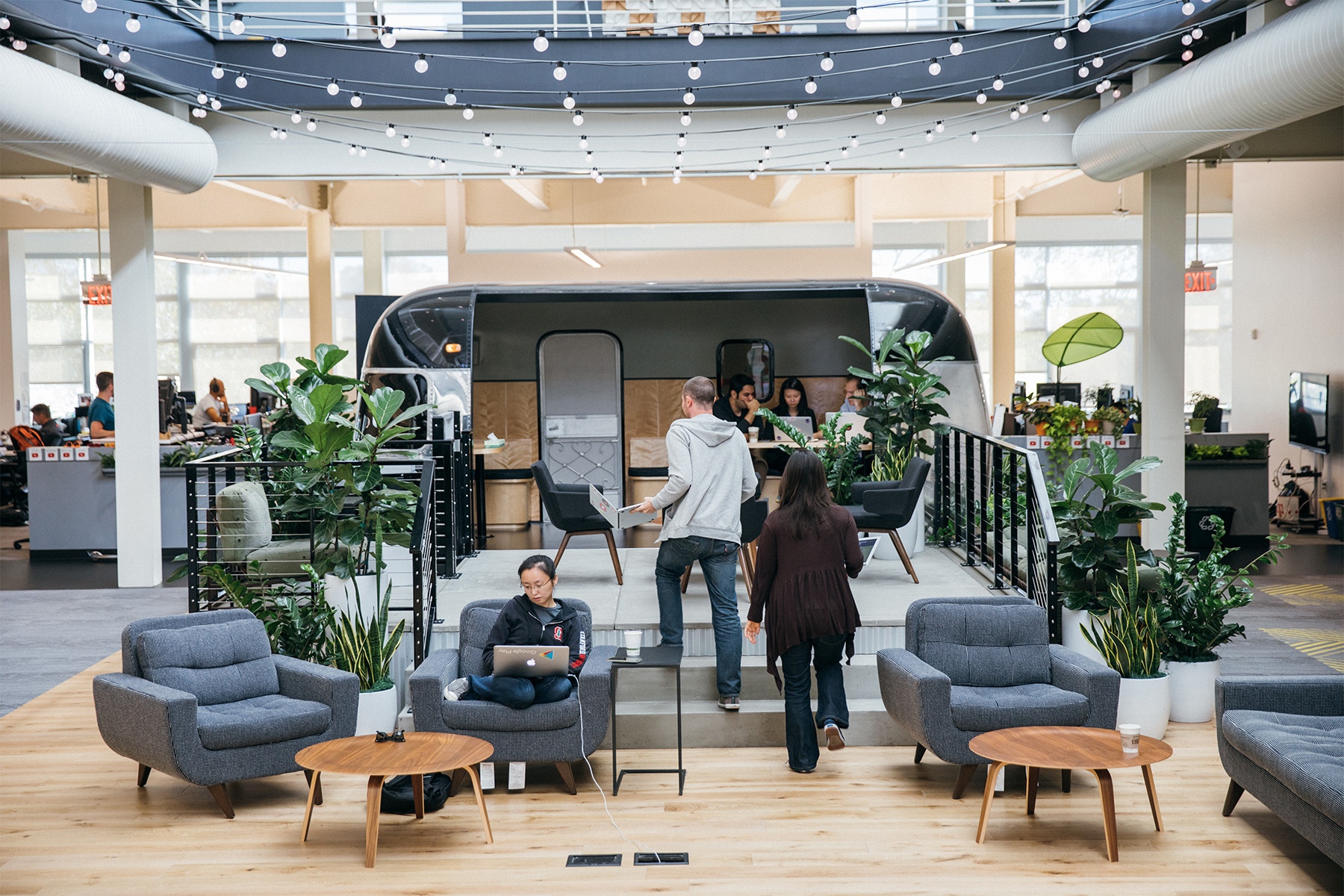 The Airstream working area within YouTube, with people on the chairs in front and sitting inside.