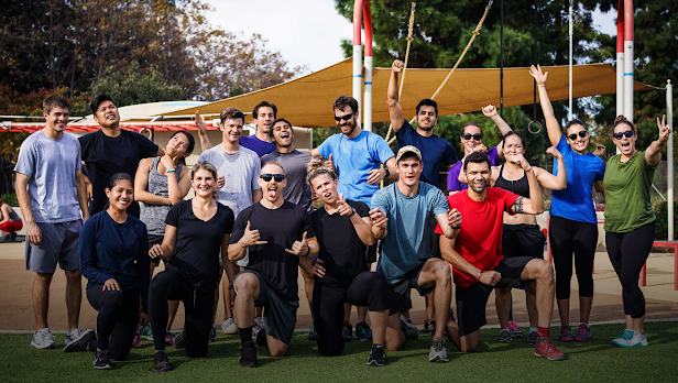 A crowd of people wearing athletic apparel smile and pose for a group picture