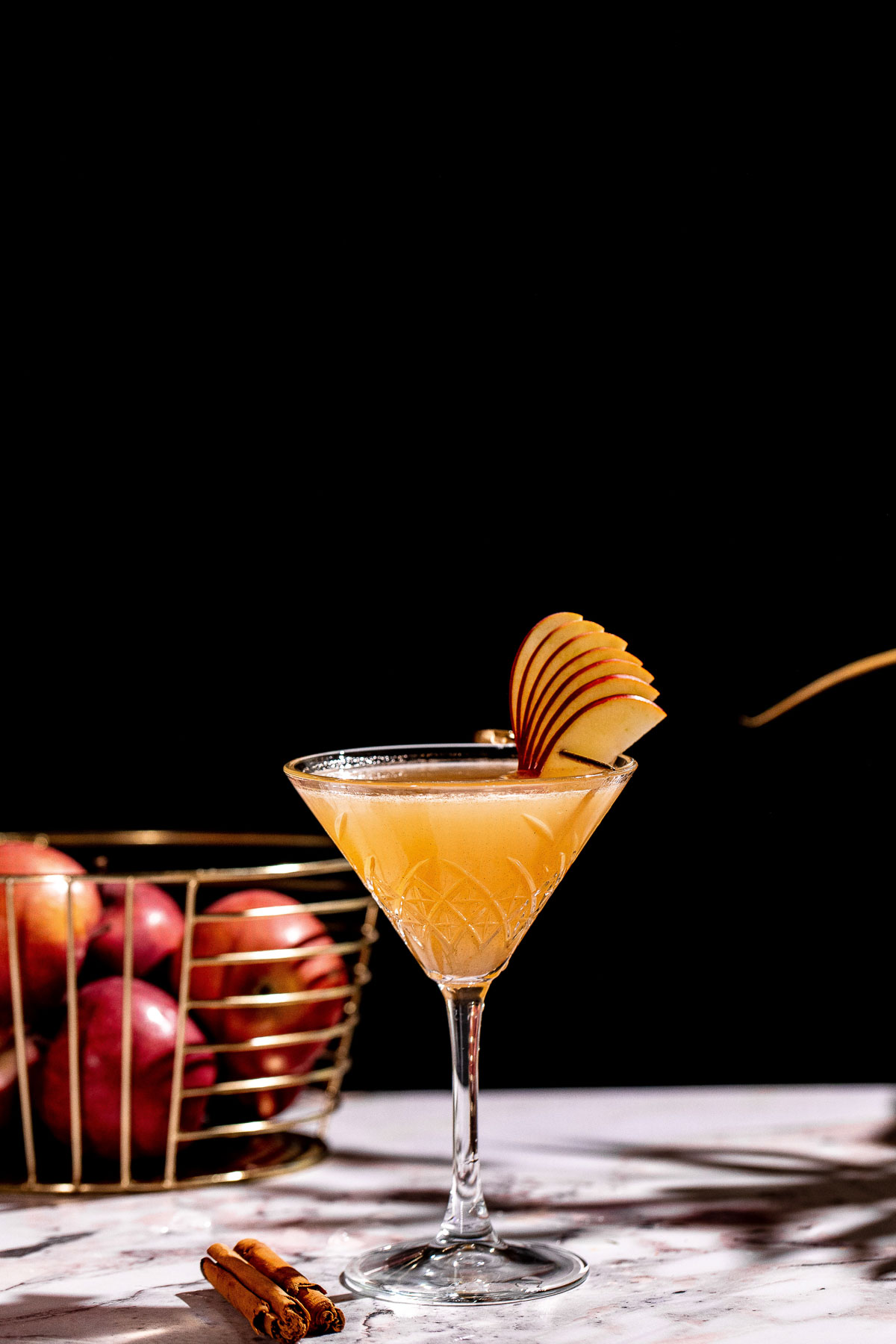 Side shot of a martini glass to show the smooth apple cider martini.