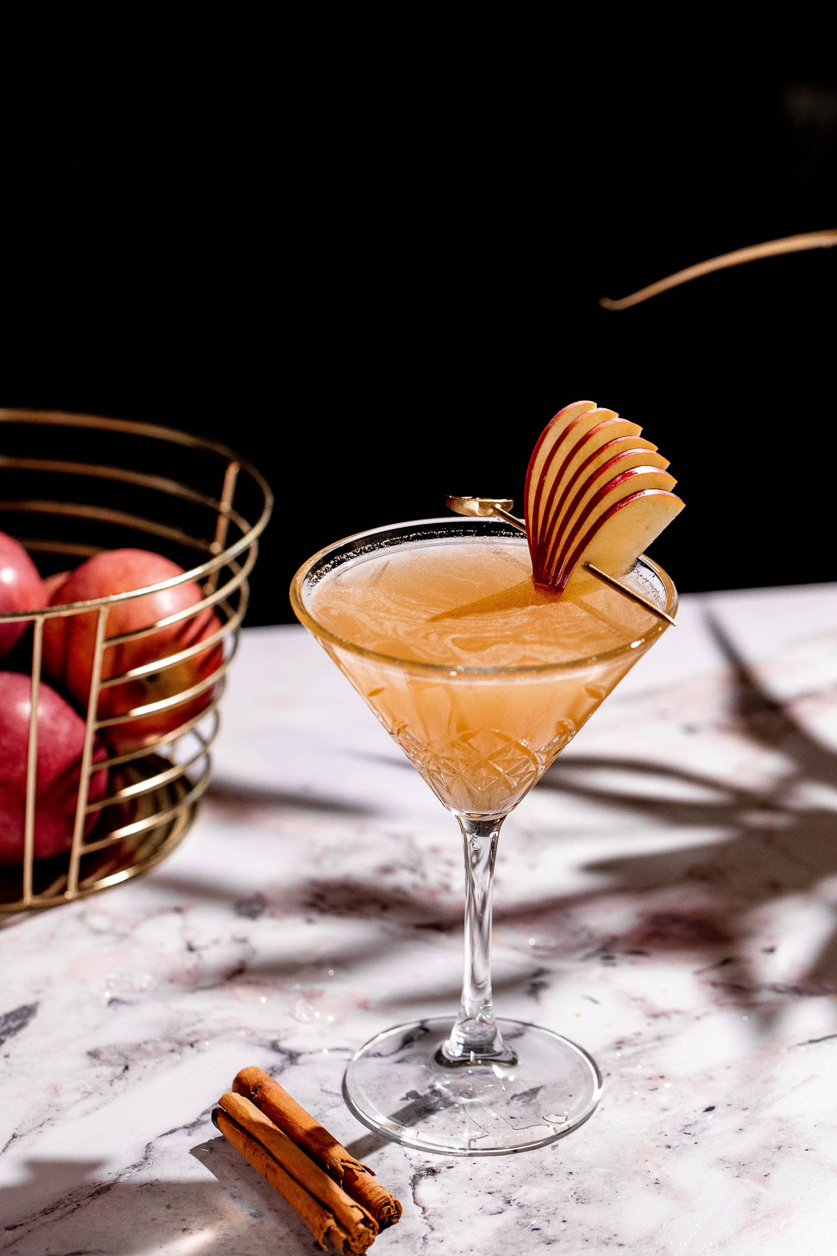 Apple cider martini in a martini glass with apple slice garnish.