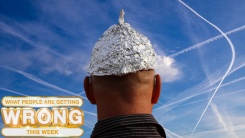 tinfoil hat wearer looks at a sky full of chemtrails 