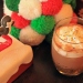 A spiked hot chocolate with whipped cream next to a snowman decoration.