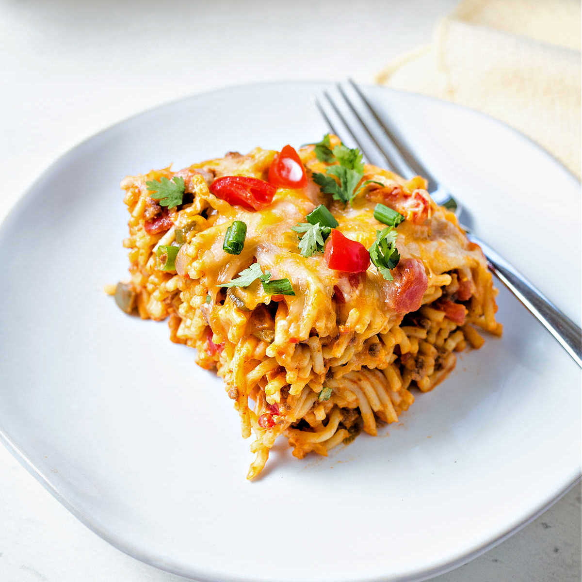 a serving of Mexican spaghetti on a white plate with a fork.