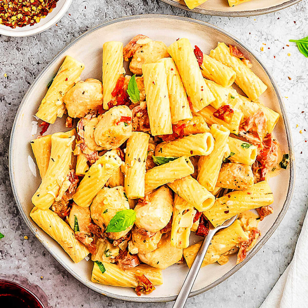 Marry Me Chicken Pasta on a plate, garnished with sun-dried tomatoes and fresh basil.