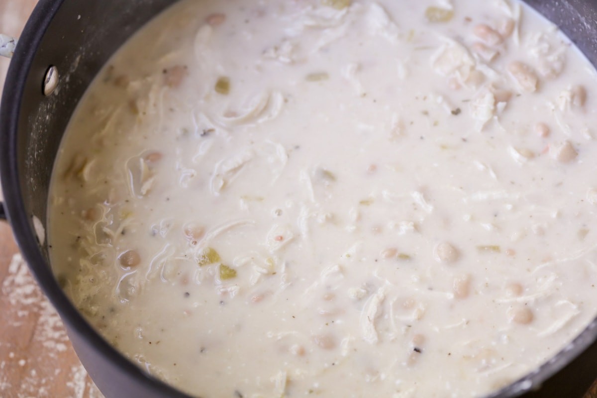 White chili cooking in a pot on the stove.