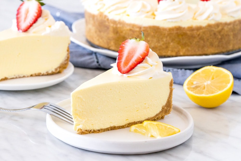 Slice of jello cheesecake with whipped cream and a strawberry on top.