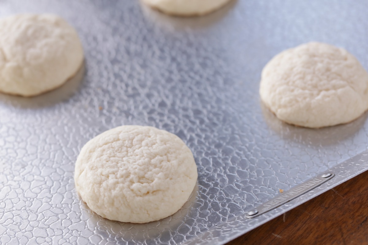 Cream cheese cookies baked and spaced on a cookie sheet