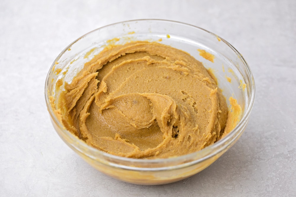 Peanut butter dough in a glass bowl.