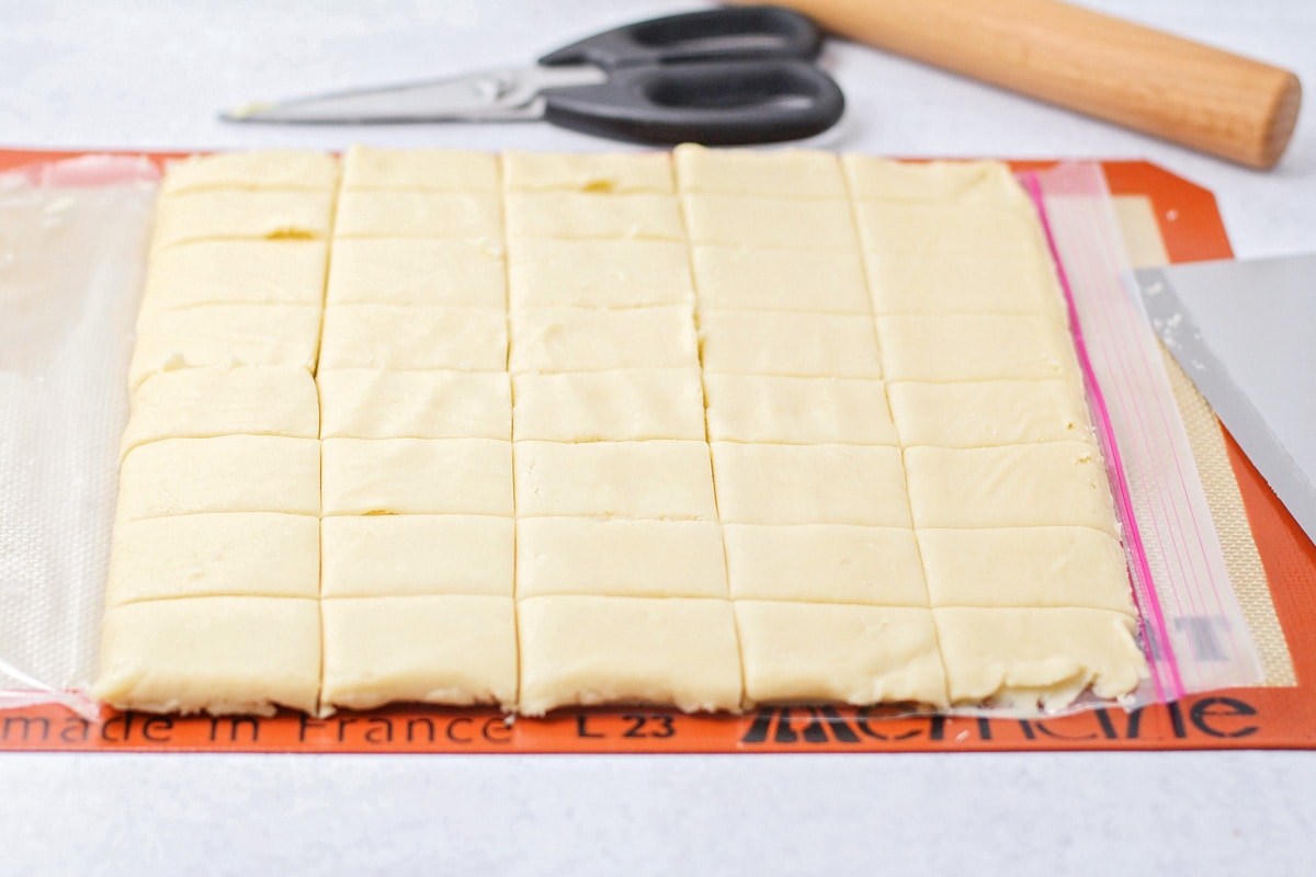 Cutting cookies dough into squares for baking.