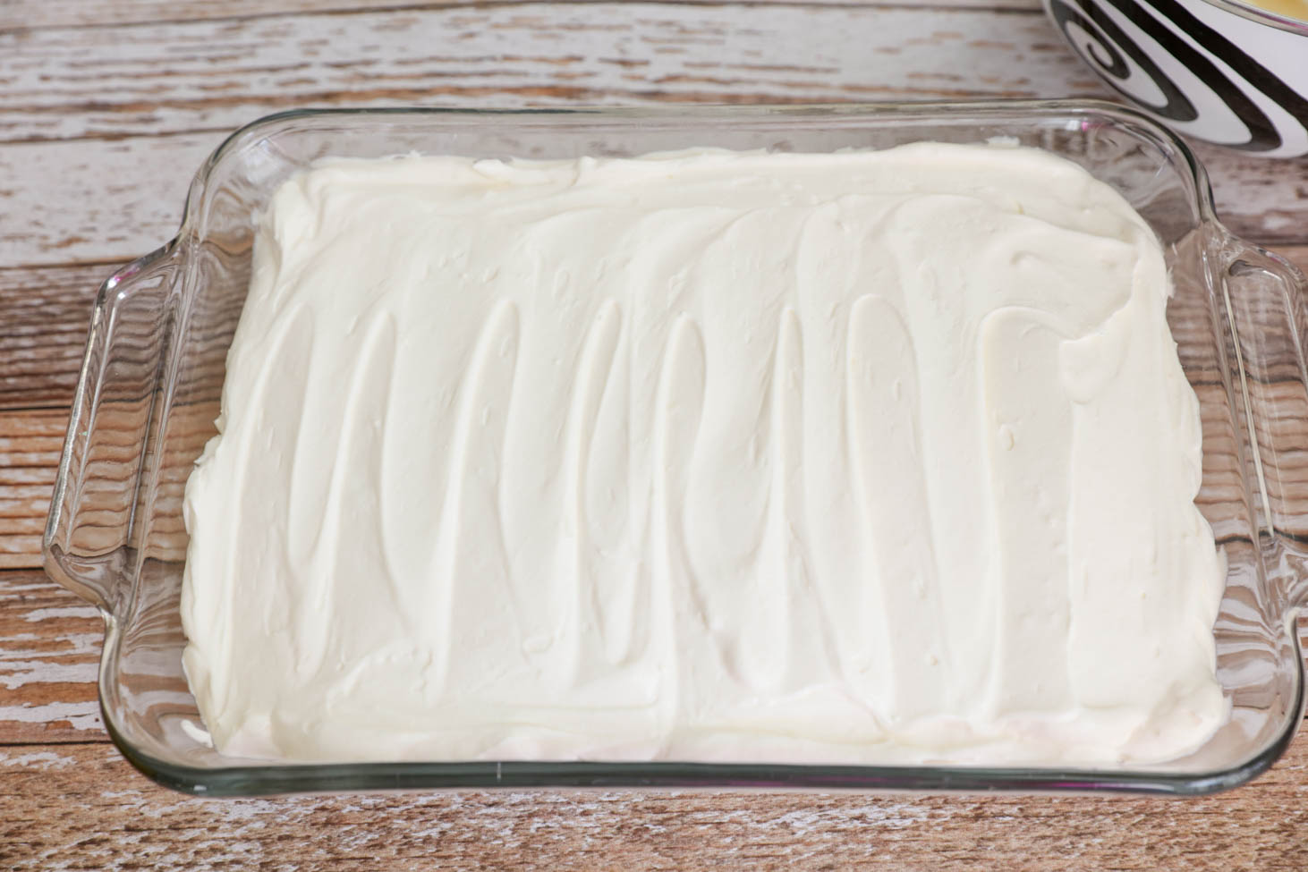 Easter dirt cake in a 9x13 pan with the cream layer smoothed out.