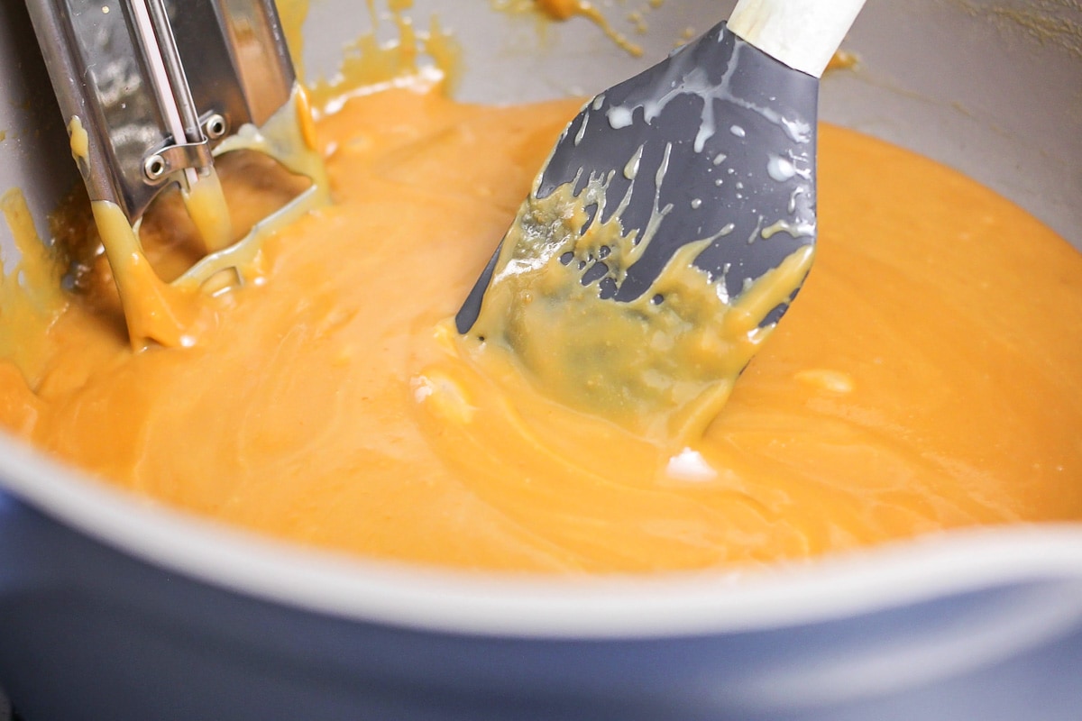 Stirring the caramel mixture in a pot on the stove.