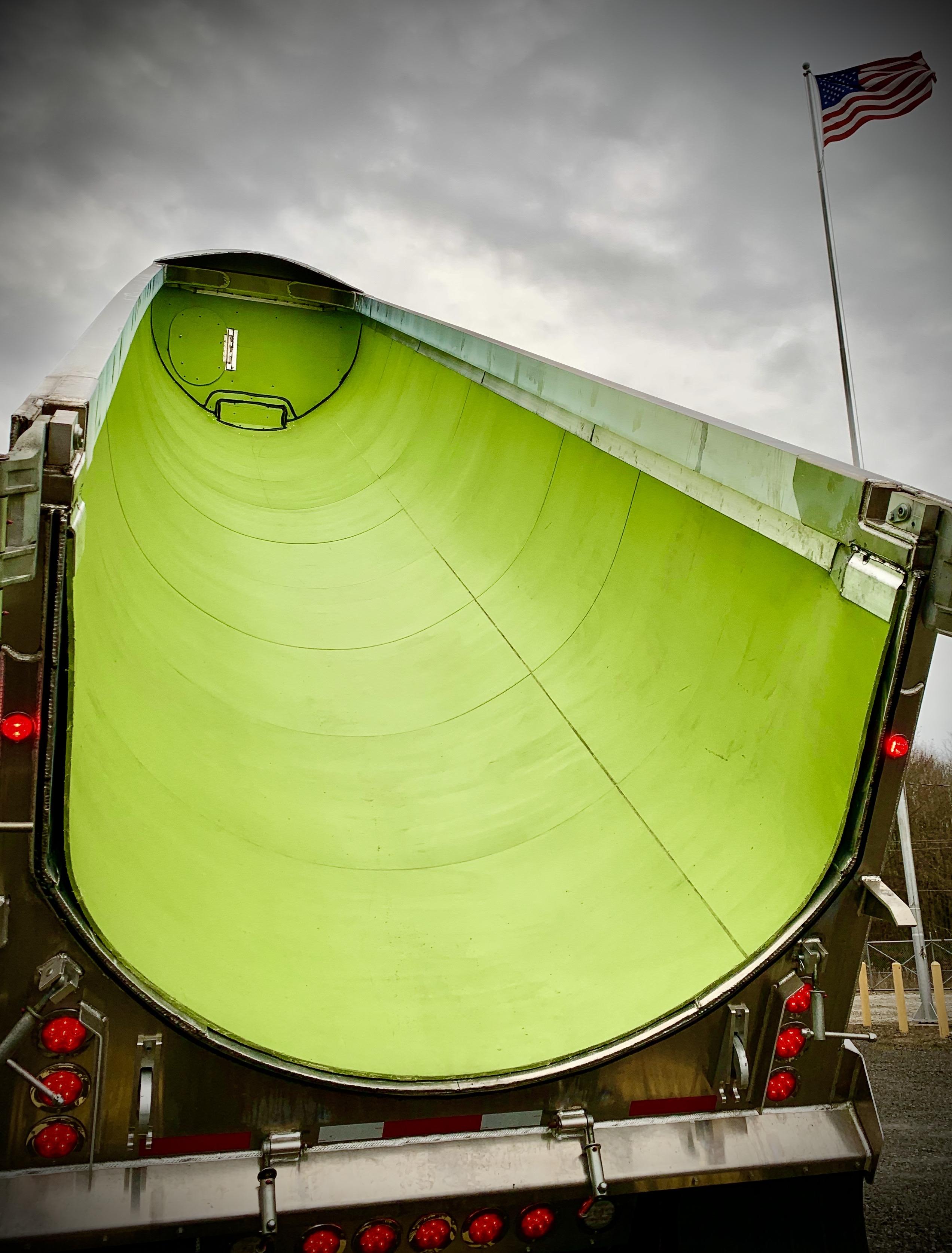 photo of a dump truck with curved green liner