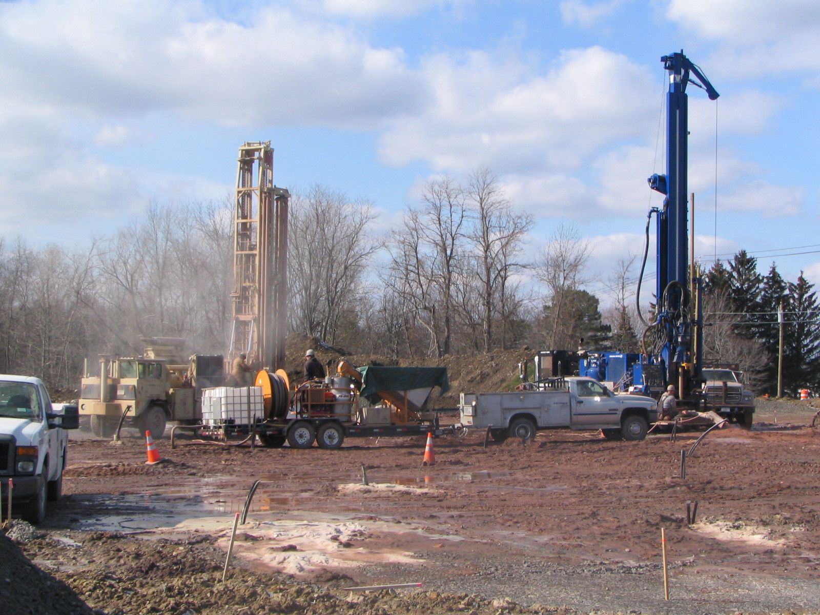 a group of construction vehicles are working in a dirt field