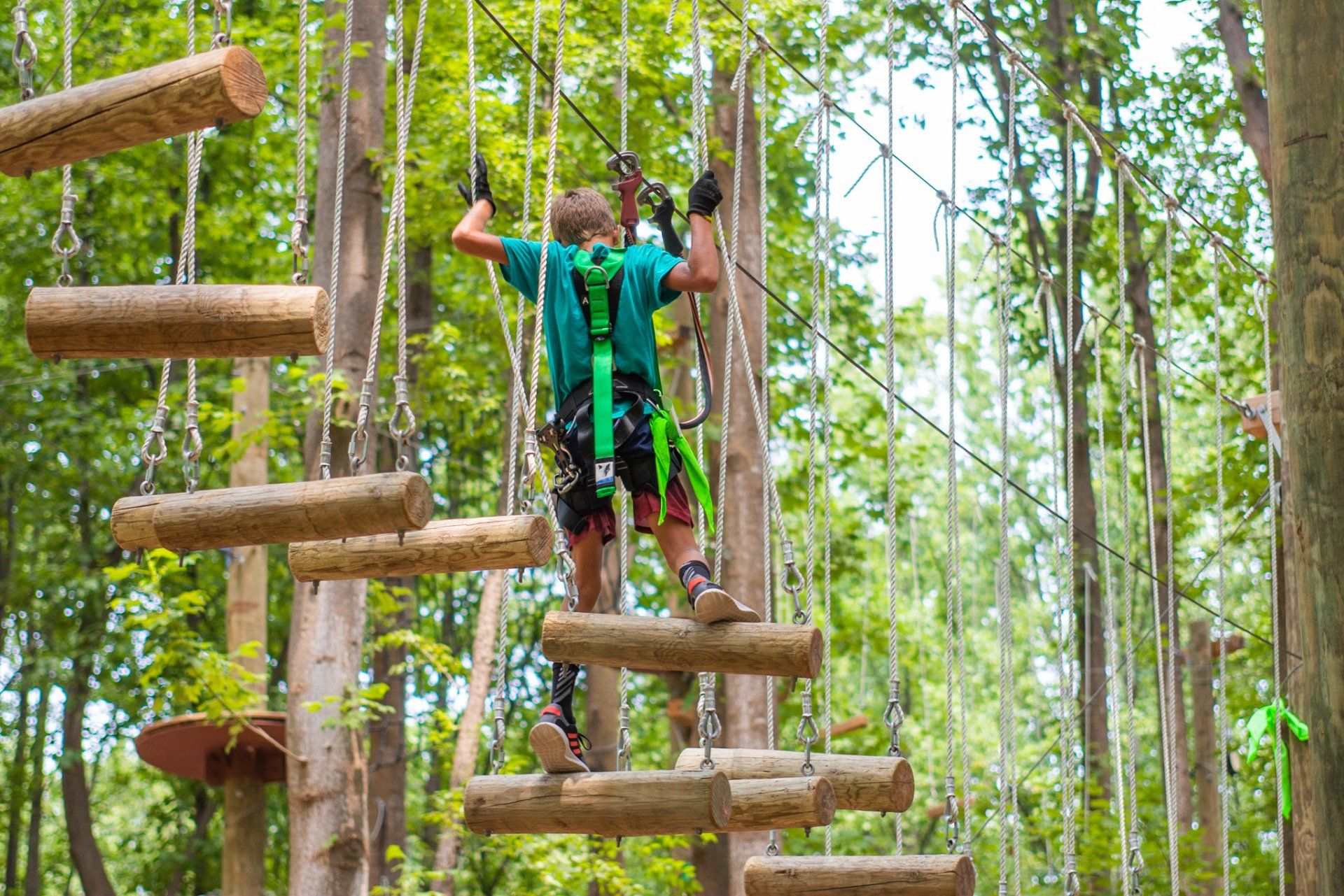 Adolescent girl climbing on high ropes course