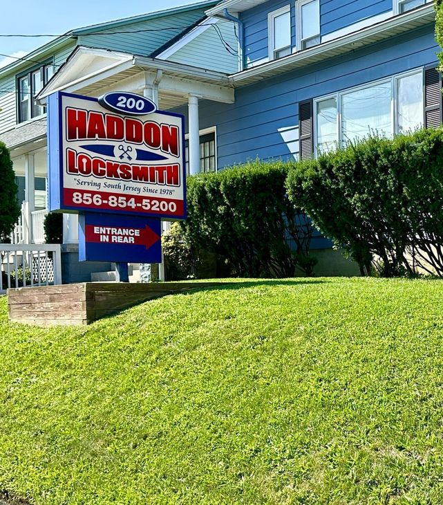 A blue house with a haddon locksmith sign in front of it