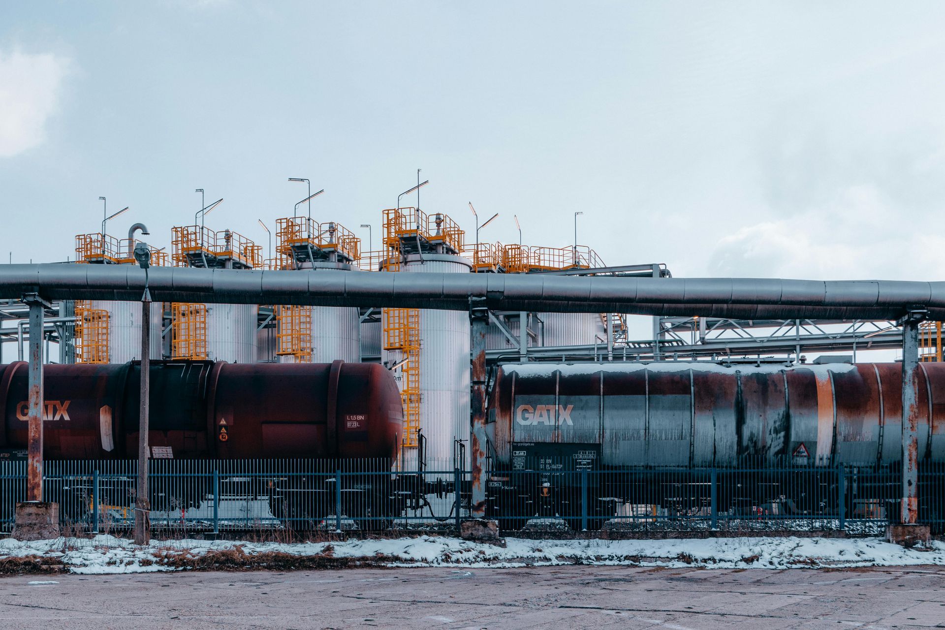 A train is parked in front of a factory.