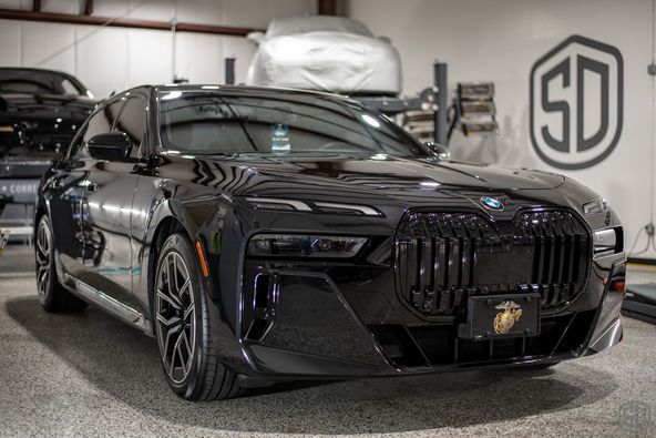 A black bmw 7 series is parked in a garage.