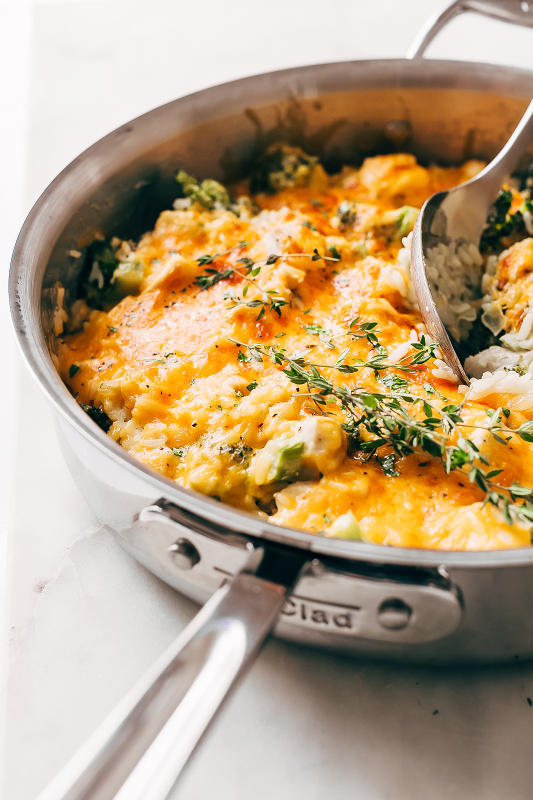 melted cheese on chicken broccoli rice casserole in stainless steel pan