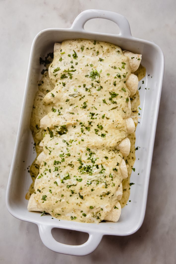 enchiladas suizas in white dish on white marble