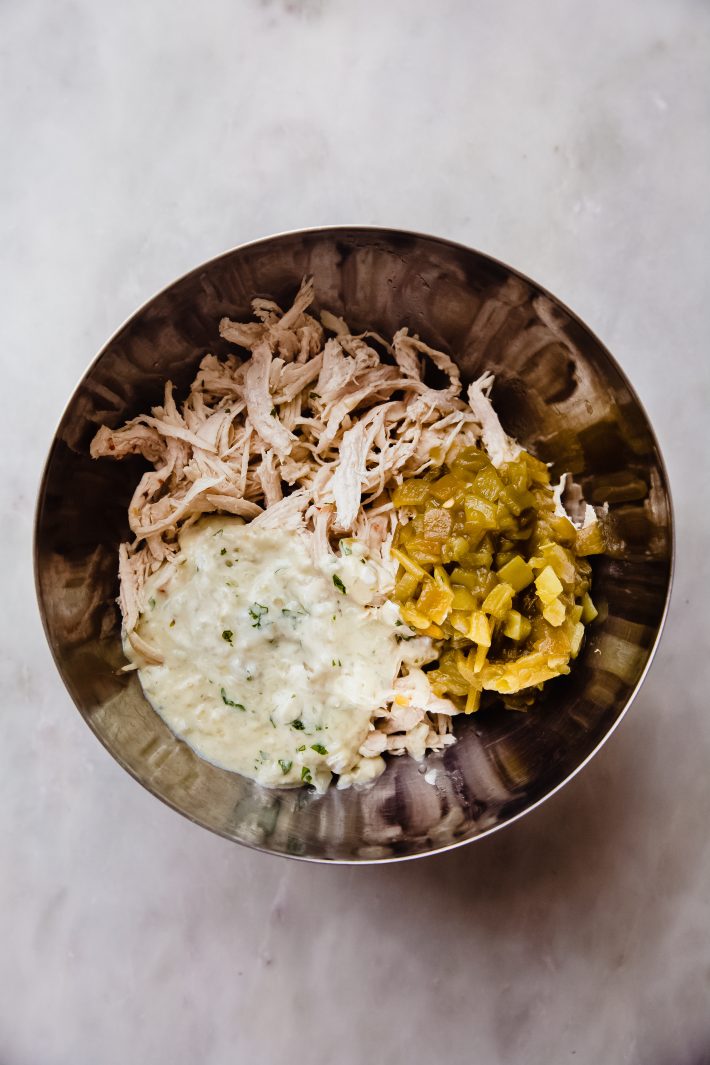 shredded chicken, diced green chilies, and cream sauce in a bowl