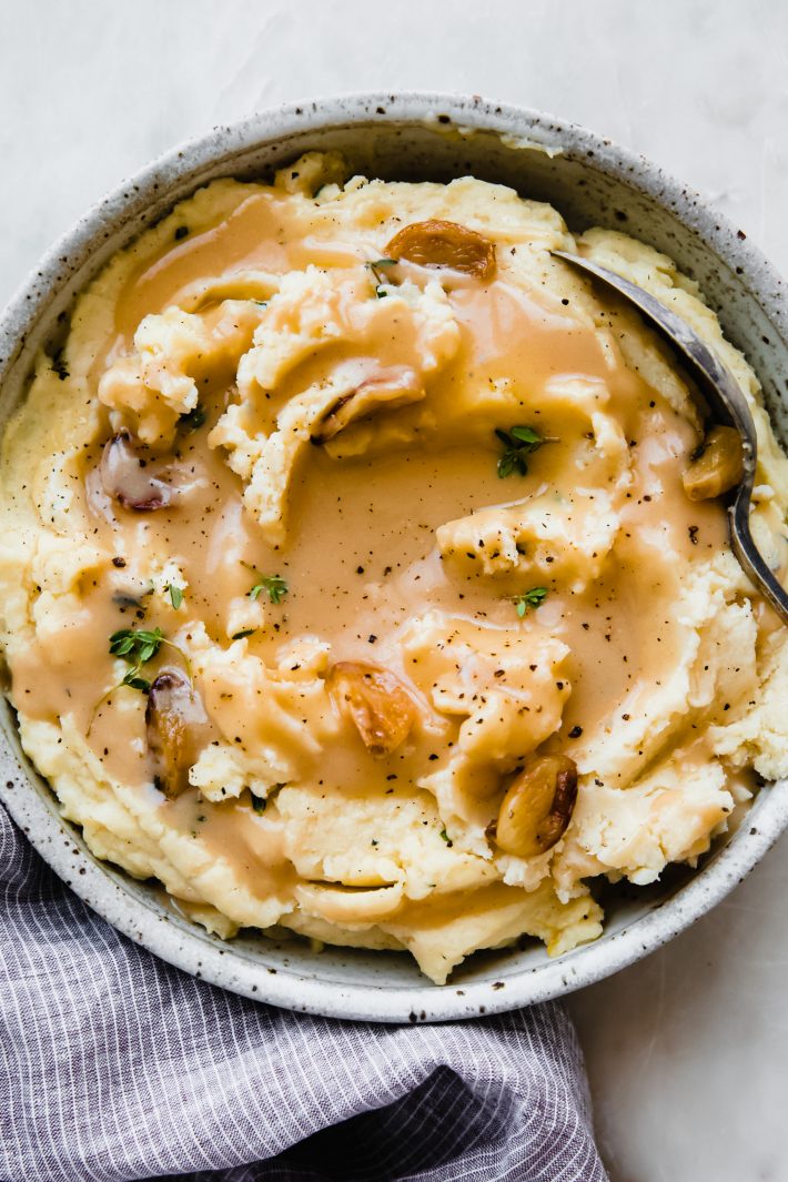 gravy poured over mashed potatoes with kitchen towel