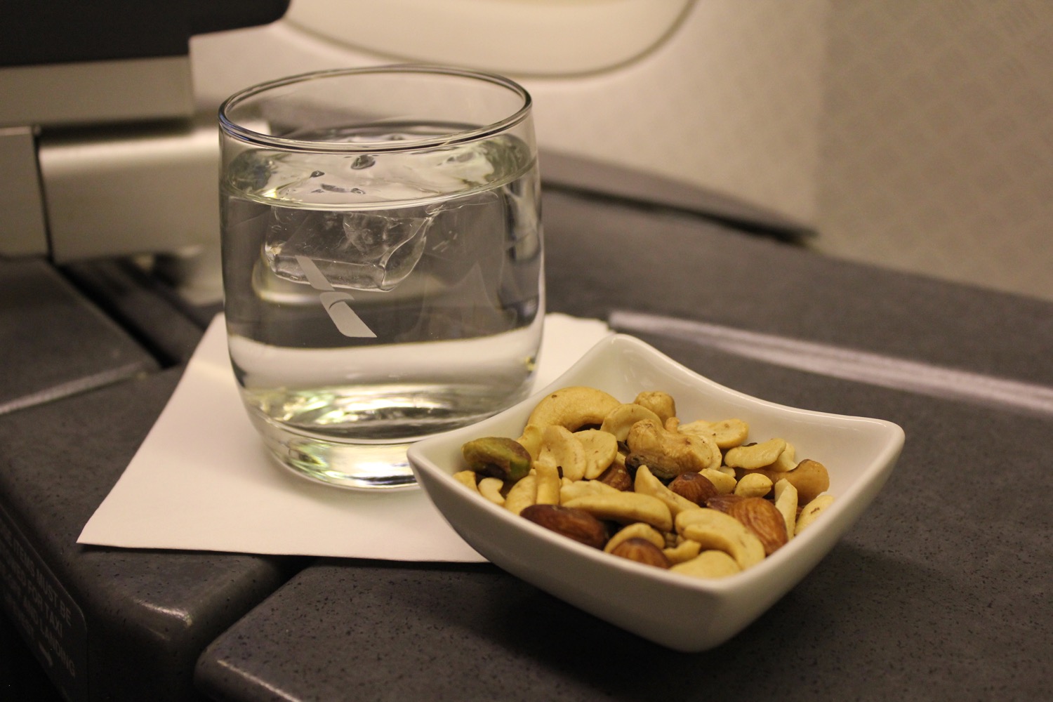 a bowl of nuts and a glass of water