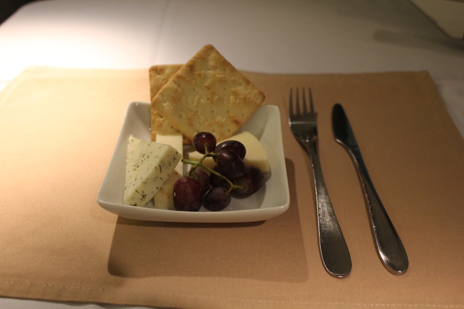 a plate of cheese grapes and crackers