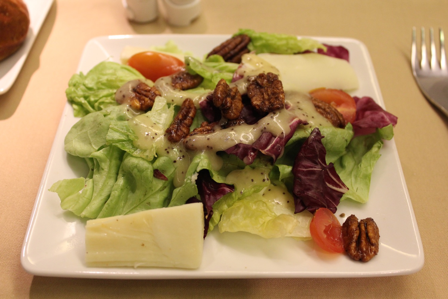 a plate of salad with nuts and cheese