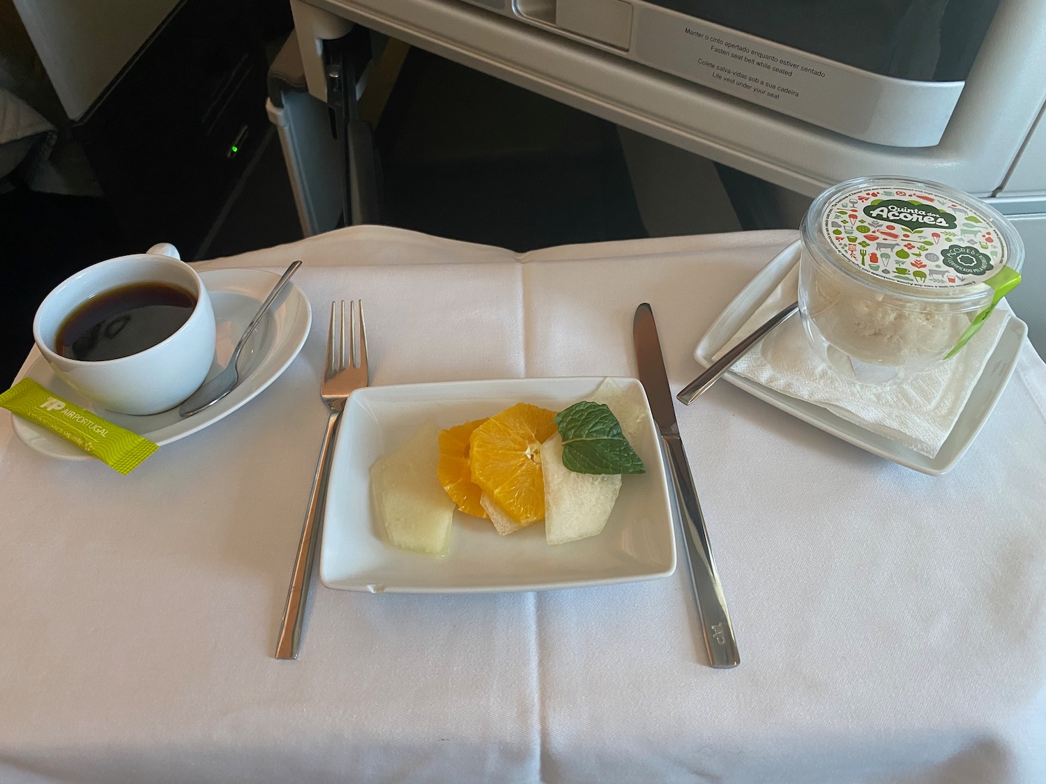 a plate of fruit and a cup of coffee on a table