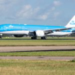 a blue and white airplane on a runway