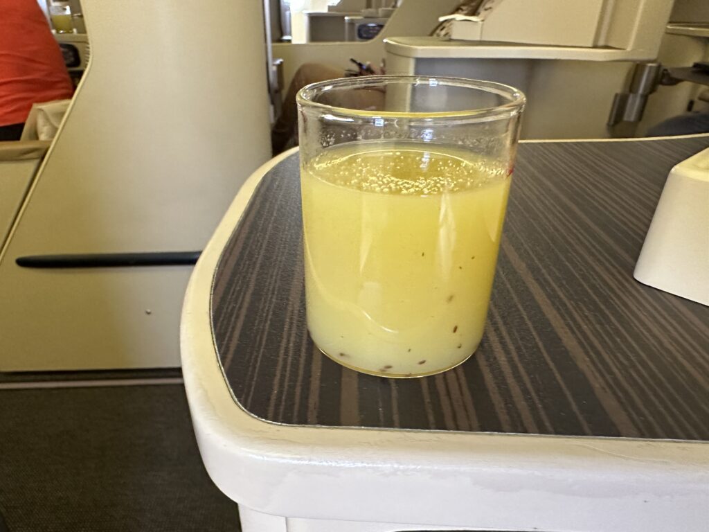 a glass of yellow liquid on a table