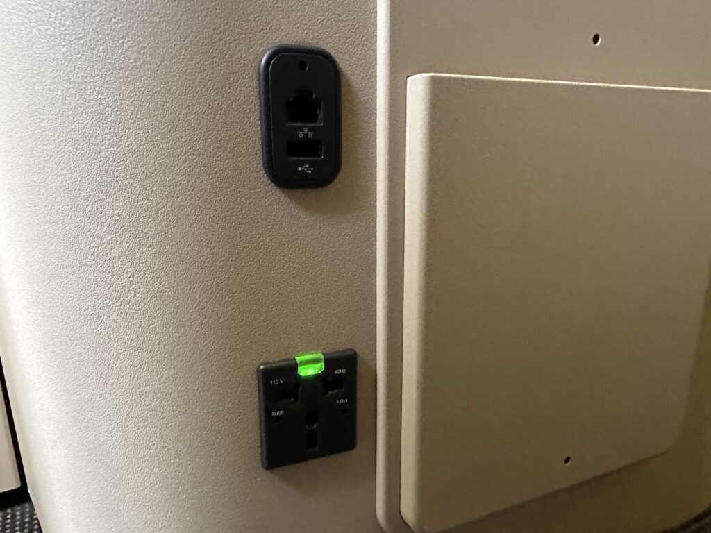 a wall with a power outlet and a green light