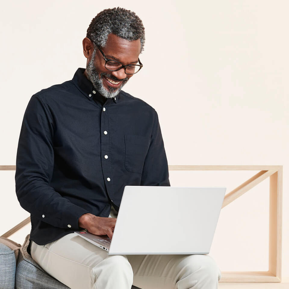 Man smiles looking at laptop