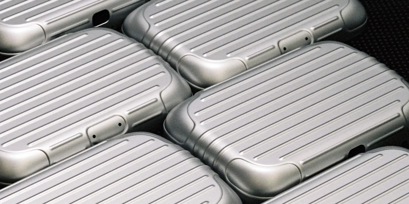 Silver suitcases stacked on a table.