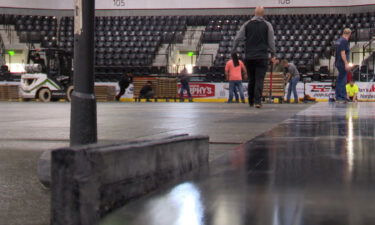 Workers assemble the hardwood floor at the Mountain America Center.