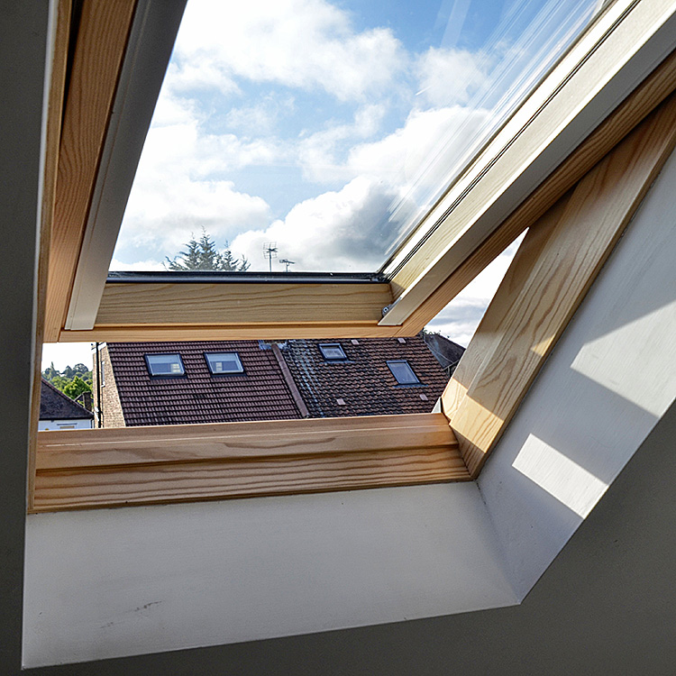 An opened Velux window with a wooden frame