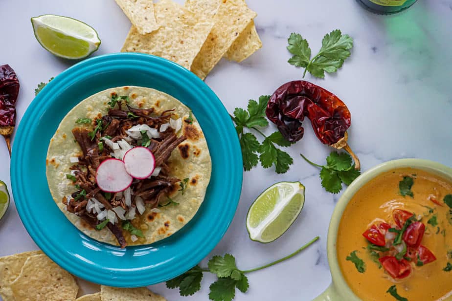 barbacoa, mexican shredded beef tacos with chips and queso, peppers, cilantro, and lime