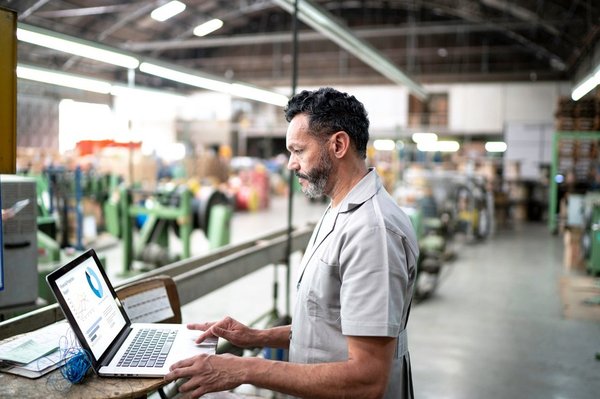 A man in a factory works on new capital purchases. 