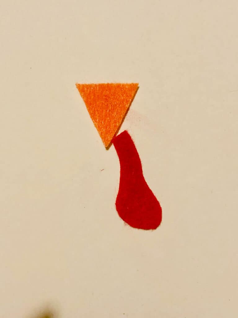 Orange triangular felt beak and a red felt turkey snood.