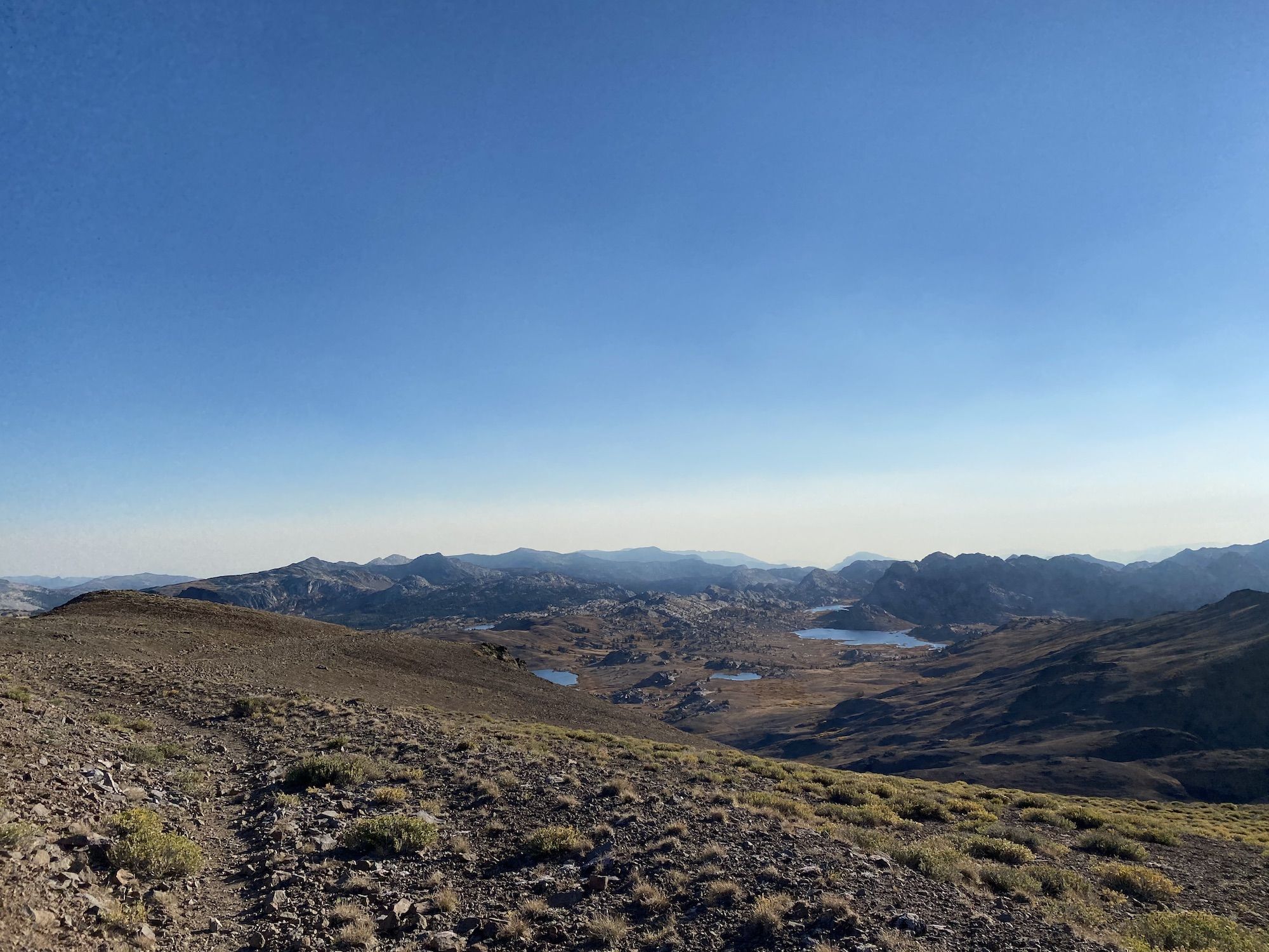 A smoky mountain landscape with lakes