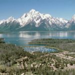 aerial photo with peaks, lake and forested area