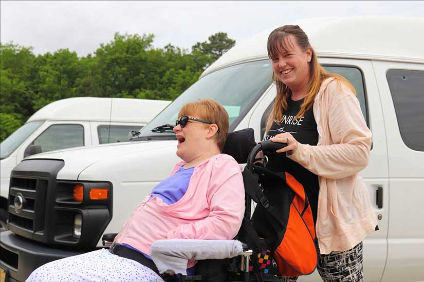 Woman pushing woman in wheelchair