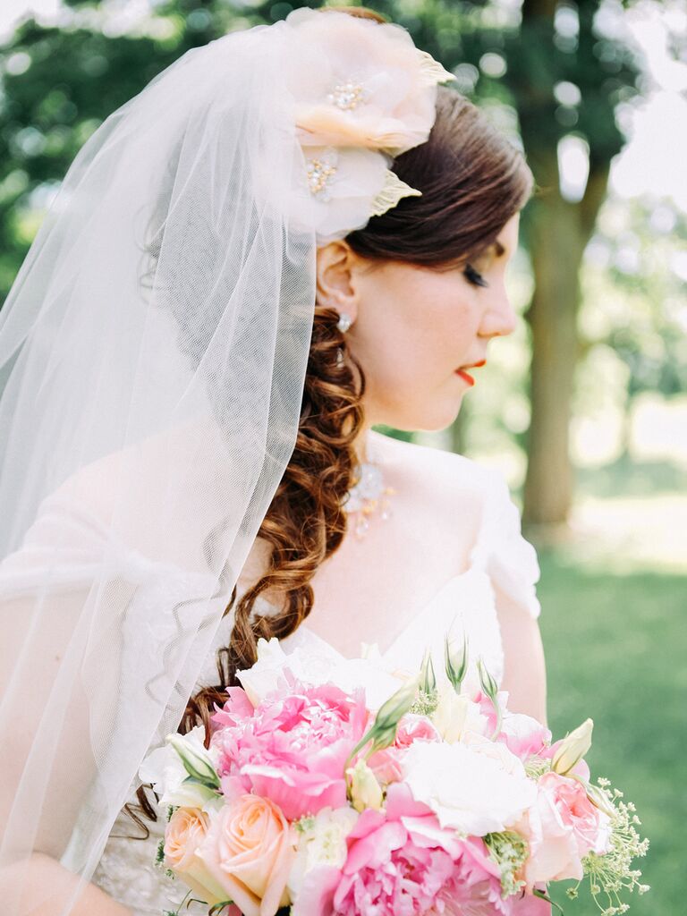 Curled wedding hairstyle with a floral hair accessory and veil