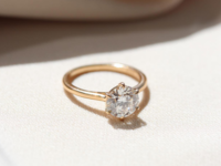 Diamond ring with gold band on white cloth