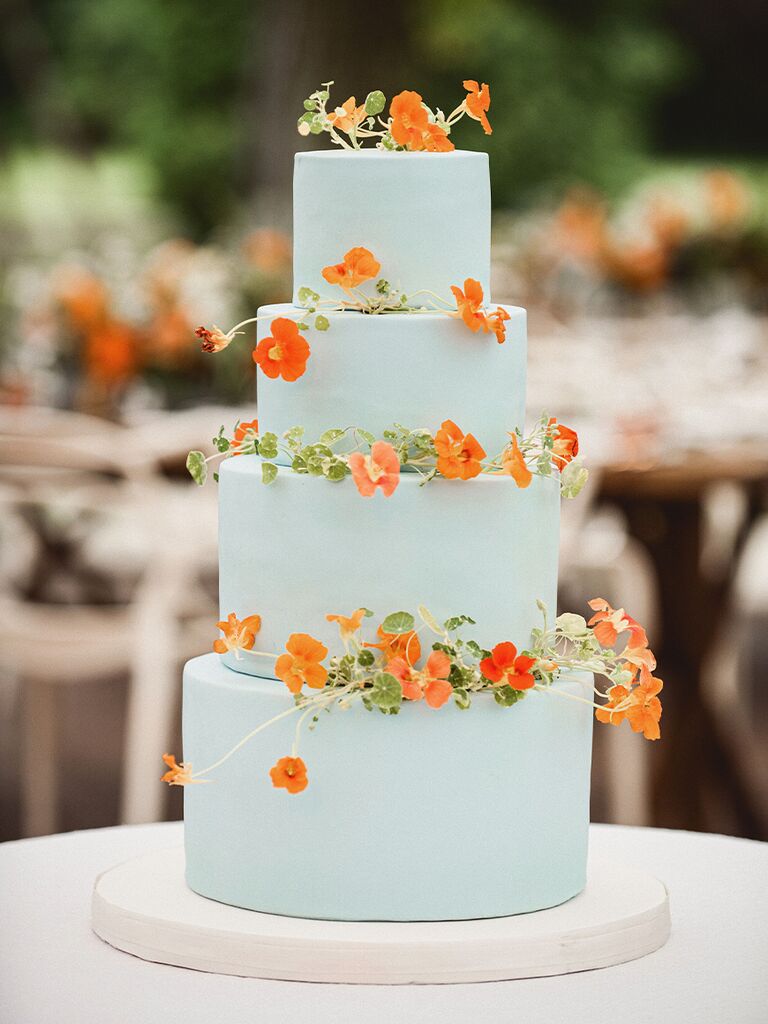 Tiered blue spring wedding cake with orange flowers