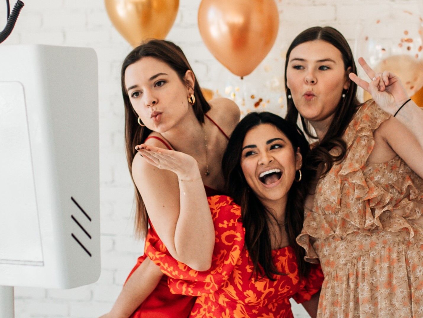 Friends posing in front of an open air photo booth