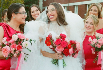 Bride with glasses smiling at bridesmaids