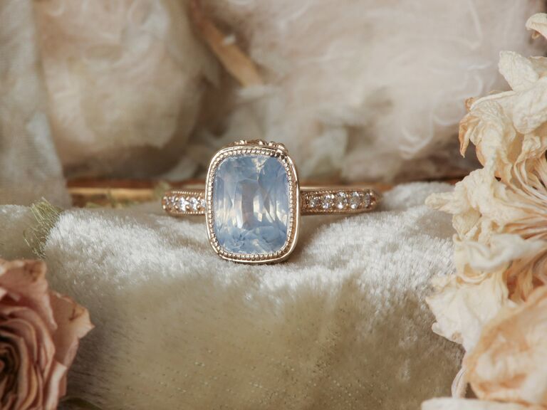 Vintage folklore-inspired engagement ring with sapphire in a milgrain bezel setting