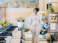 Woman walking in a bridal shower event space surrounded with blue and yellow florals