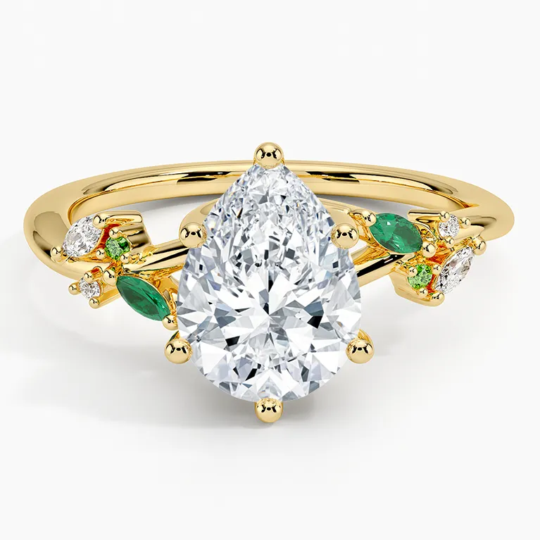 Pear shaped diamond engagement ring with lab emerald accents inspired by Taylor Swift